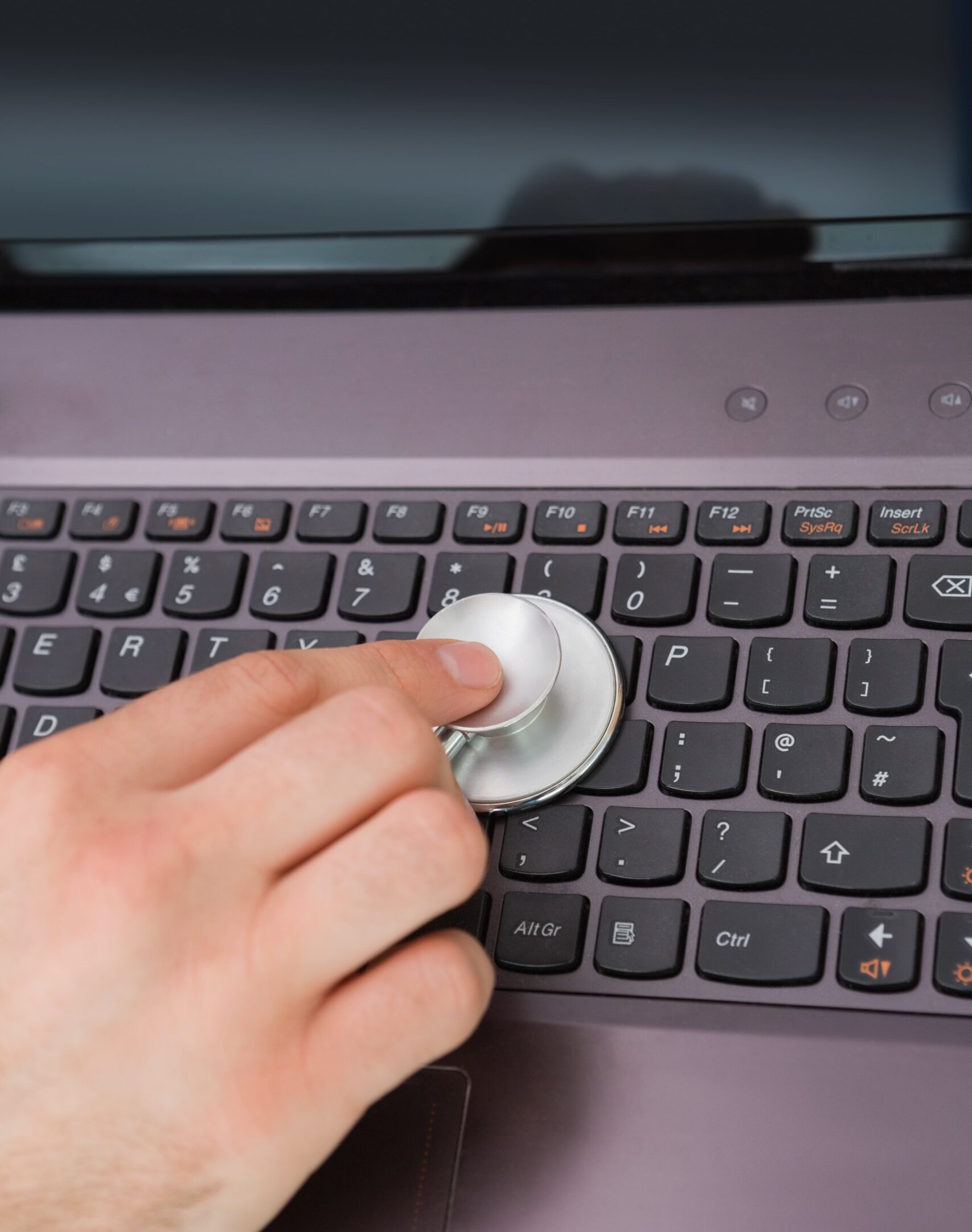hand-examining-laptop-keyboard-with-stethoscope-min hand-examining-laptop-keyboard-with-stethoscope-min
